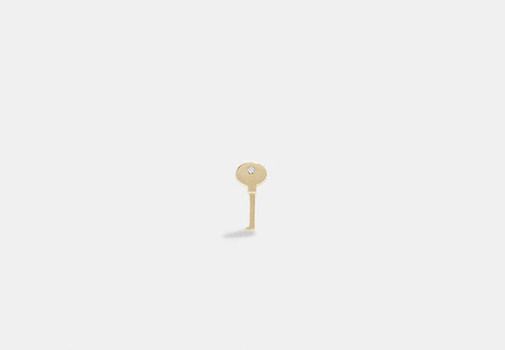 Pendiente único tipo dormilona de oro de 14 quilates con forma de llave - COACH® - Modalova