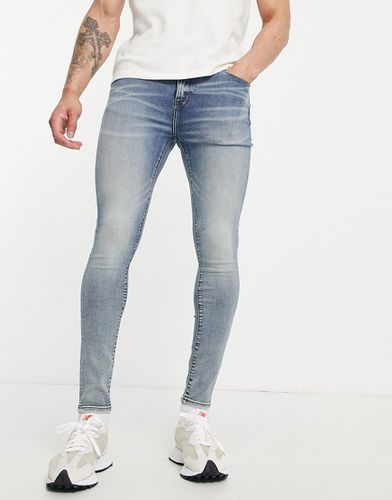 Jean seconde peau en tissu power stretch - Délavage moyen teinté - Asos Design - Modalova