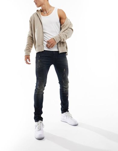 Jean skinny à abrasions - foncé teinté - Asos Design - Modalova