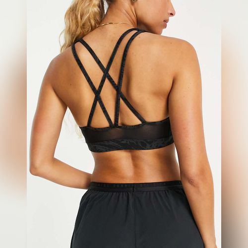 Nike Pro Training - Brassière de sport asymétrique maintien moyen en tissu  Dri-FIT avec logo virgule - Noir